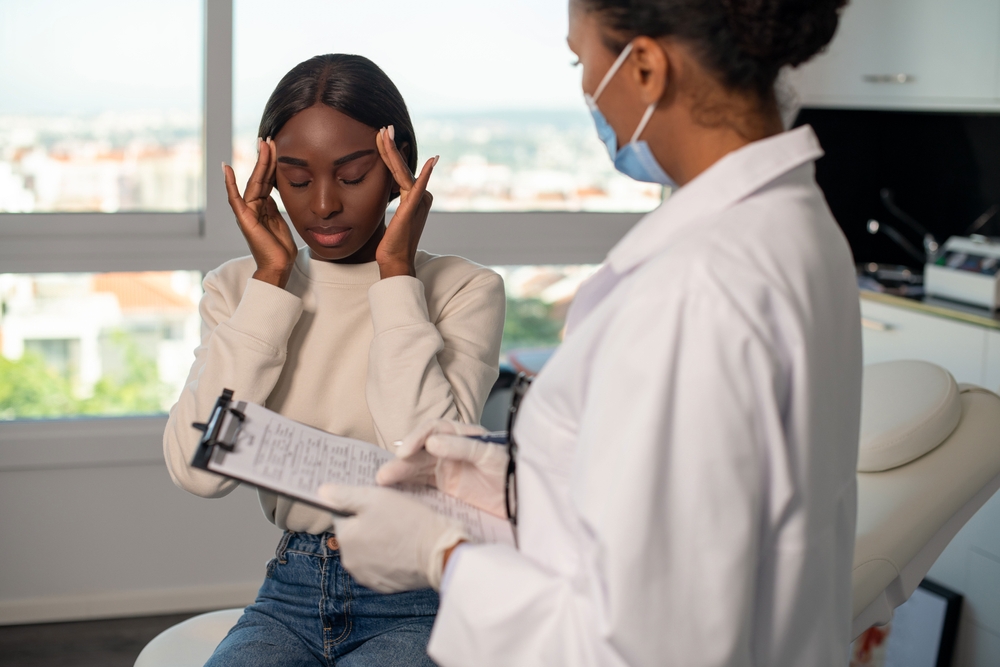 Woman,Suffering,From,Migraine,Visiting,General,Practitioner,In,Clinic.,African